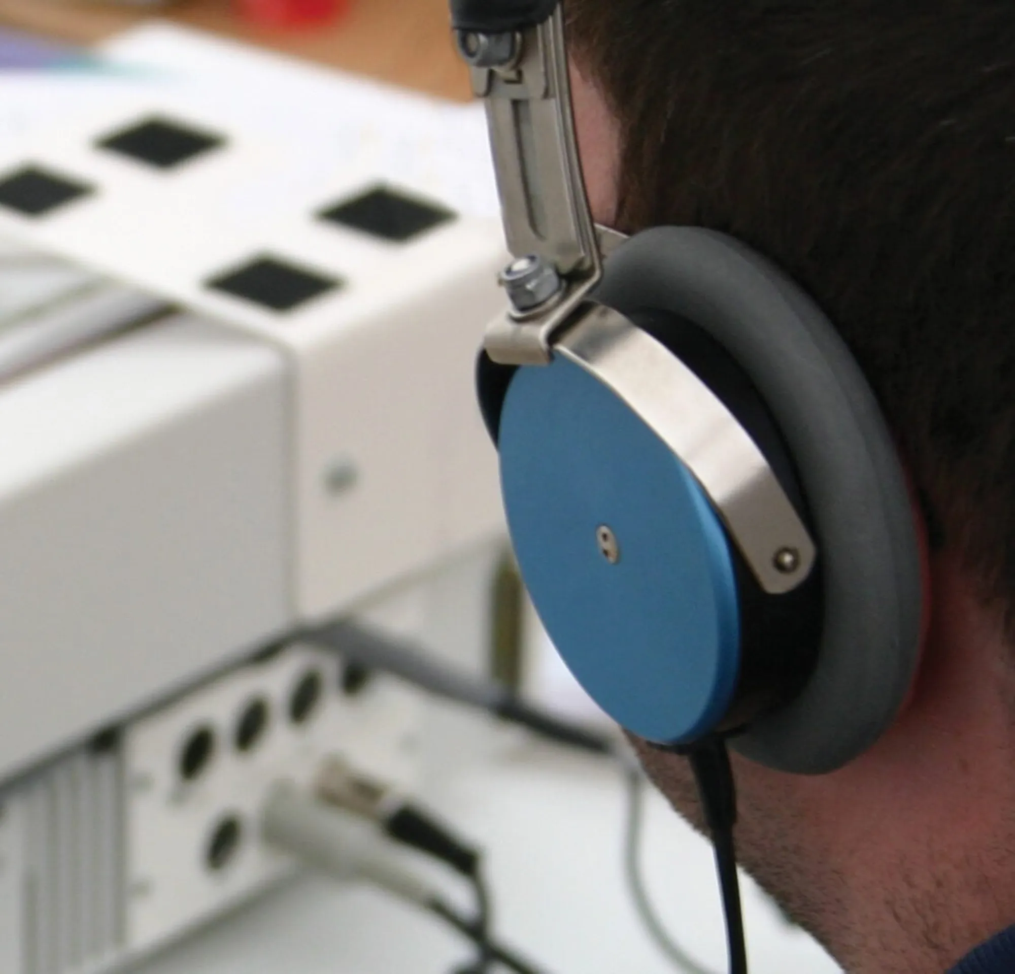 Person wearing headphones in front of equipment.