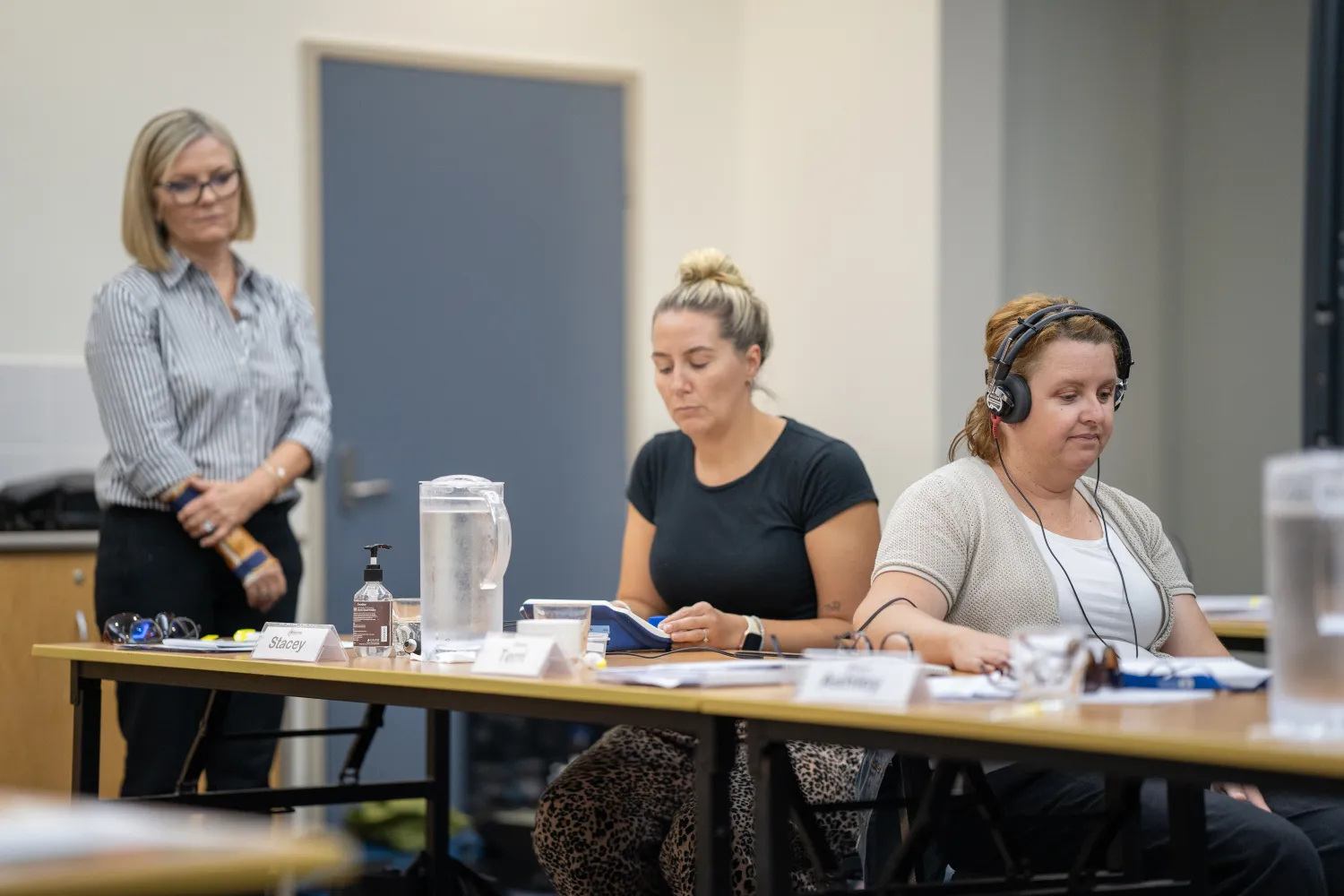 Participants conducting a hearing test with instructor observing