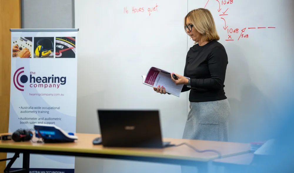 Jo teaching a class in front of a whiteboard.