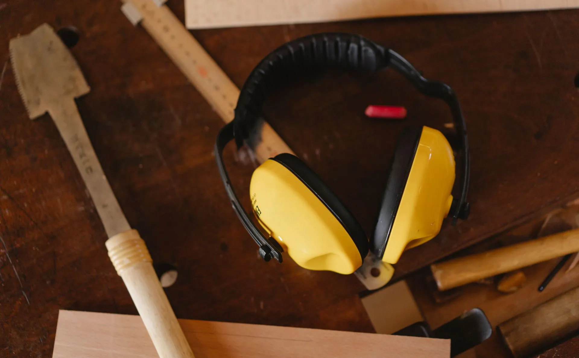 Earmuffs on a wodden workshop table with other tools
